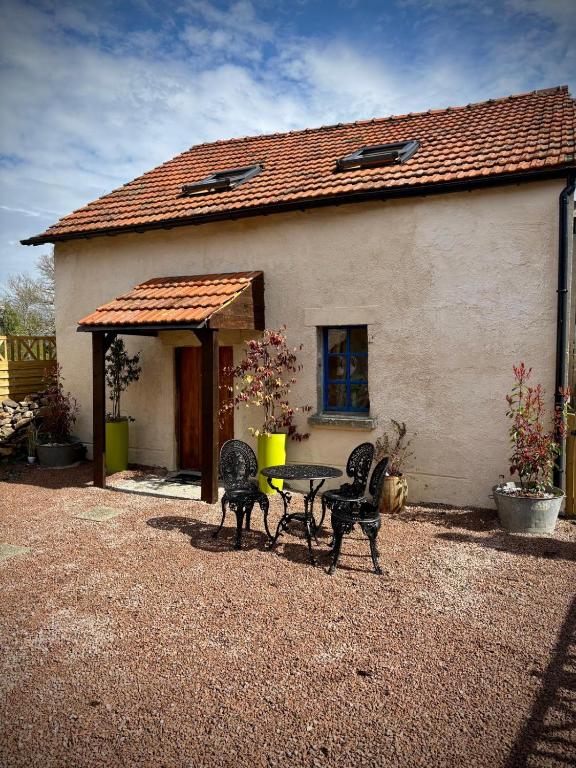 une table et des chaises devant une maison dans l'établissement La petite nid, à La Celle-sous-Gouzon