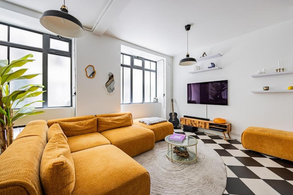 un salon avec un canapé et une télévision dans l'établissement Beautiful Loft#Canal St-Martin#2bedrooms, à Paris