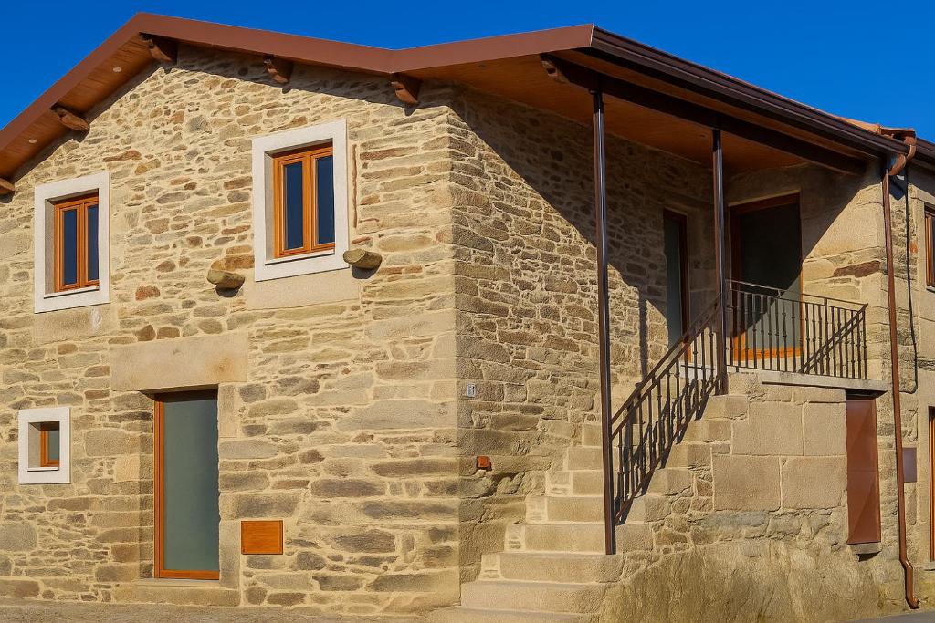a stone house with a porch and stairs on it at Casa Madureira - Paraíso centenário do Douro in Sabrosa