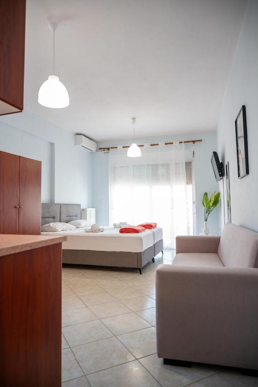 a living room with a bed and a couch in a room at Theros Apartment Preveza in Preveza