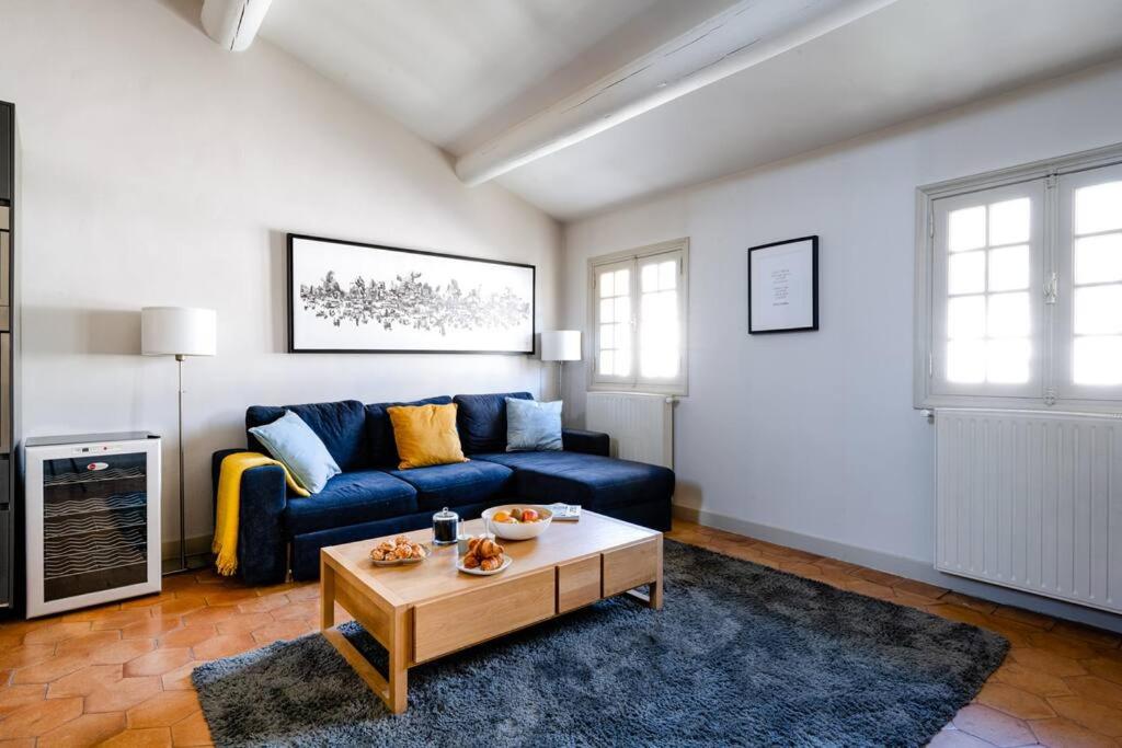 un salon avec un canapé bleu et une table basse dans l'établissement La Lucarne du Palais - Clim et Wifi - Vue sur le Palais des Papes à 20m, à Avignon