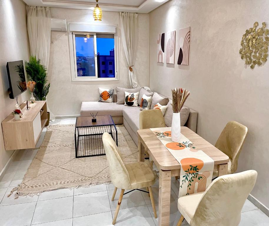 a living room with a table and a couch at Appartement cosy 2 min aéroport Marrakech 2 chambres bien équipé in Marrakech