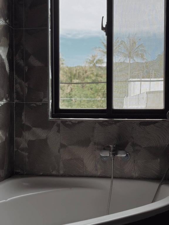 a bathroom with a bath tub and a window at E-Ping Castle Hotel in Nanwan