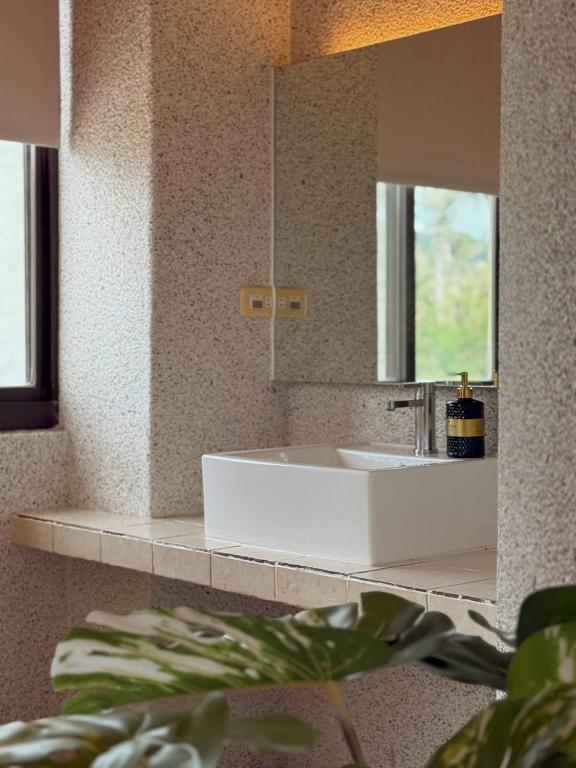 a bathroom with a white sink and a mirror at E-Ping Castle Hotel in Nanwan