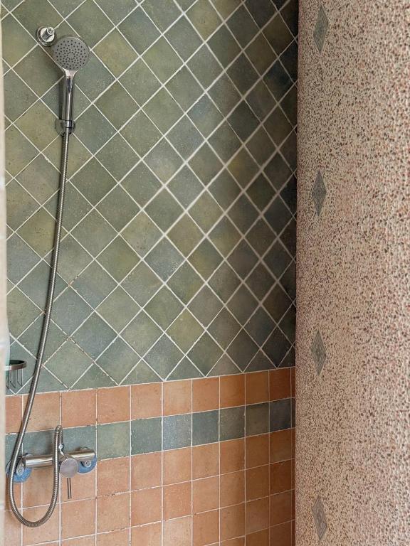 a shower in a bathroom with brown tiles at E-Ping Castle Hotel in Nanwan
