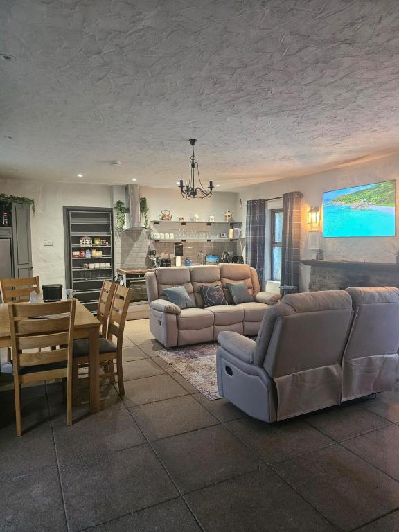 a living room with a couch and a dining room at The Gallery Cottage in Castledawson