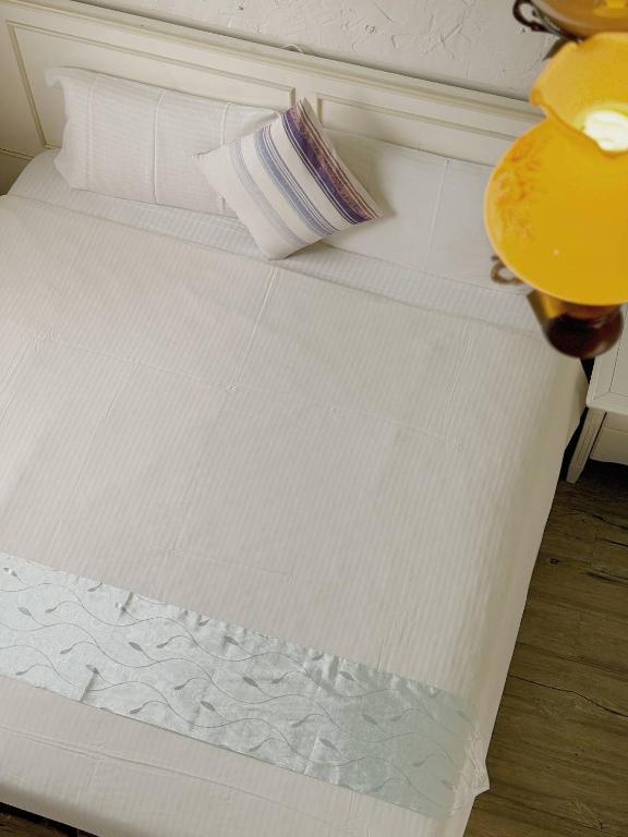 a close up of a bed with a white bedsheet at E-Ping Castle Hotel in Nanwan