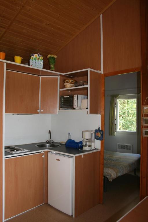 a kitchen with a stove and a sink in a room at La Ptite Ferme de Caro in Meyrignac-lʼÉglise