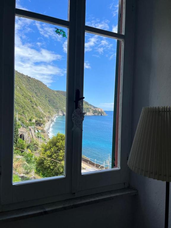 a window with a view of a beach and the ocean at La Scuna Guest House in Corniglia