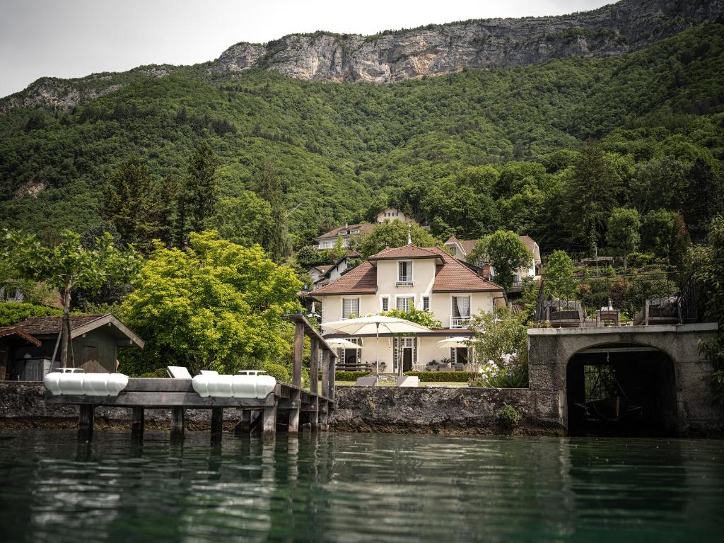 un groupe de maisons sur la rive d'une masse d'eau dans l'établissement Venez Chez Vous La Villa des Pensières, à Veyrier-du-Lac