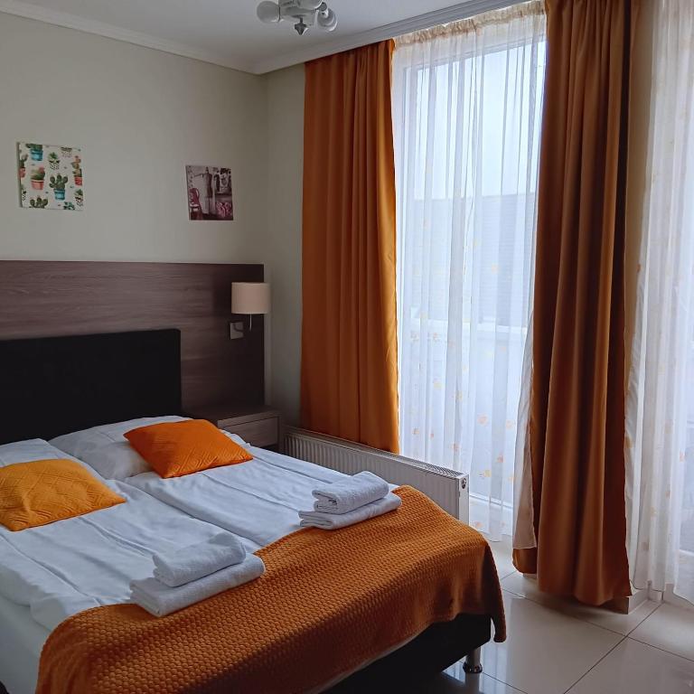 a bedroom with a bed and a large window at Hotel Cara Vita Cologne in Cologne