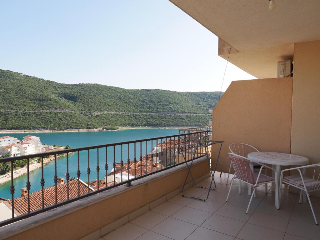 a balcony with a table and chairs and a view of the water at Villa Njavro in Neum