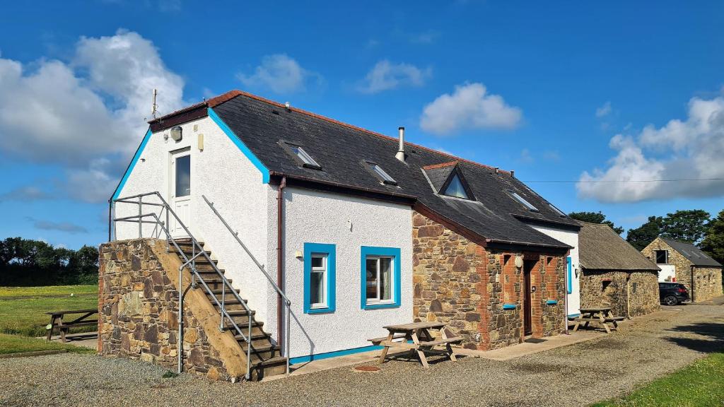 a small white building with a ladder and a picnic table at Newgale Lodge in Newgale