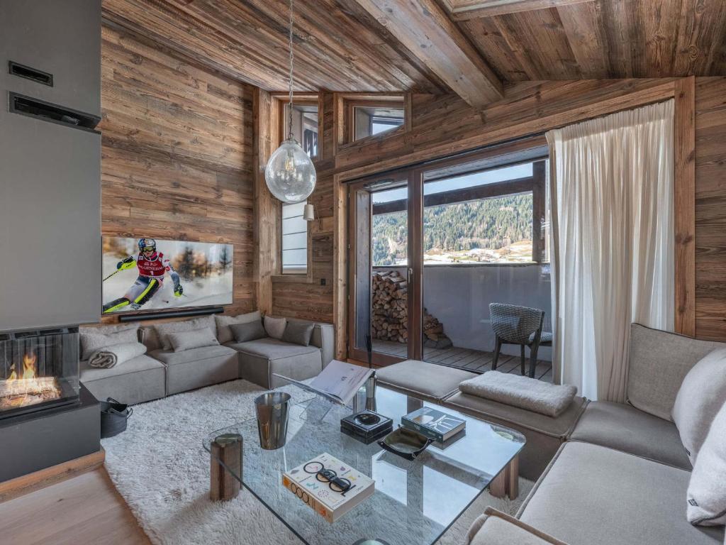 un salon avec un canapé et une table dans l'établissement Chalet à Megève avec Wellness: 6 adultes, 4 enfants, ascenseur, terrasse, cheminée, accès sauna/piscine - FR-1-569-56, à Megève