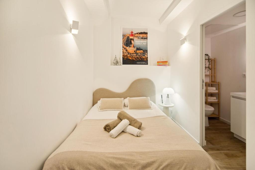 - une chambre blanche avec un lit et deux oreillers dans l'établissement Elegant appt- AC- 1BR 2P - Centre St Tropez, à Saint-Tropez