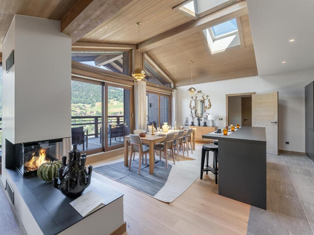 une cuisine et une salle à manger avec une cheminée dans une maison dans l'établissement Duplex à Megève avec spa, piscine, salle de sport et cheminée - FR-1-569-32, à Megève