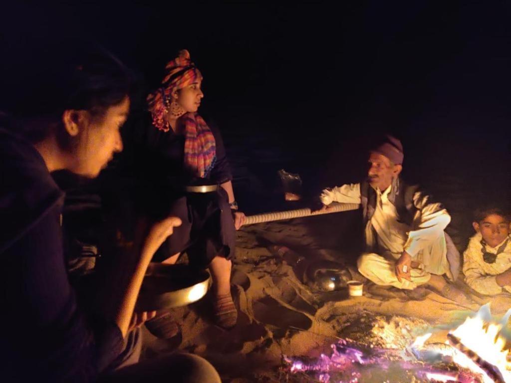 a group of people sitting around a fire at Killa Bhawan Lodge in Jaisalmer