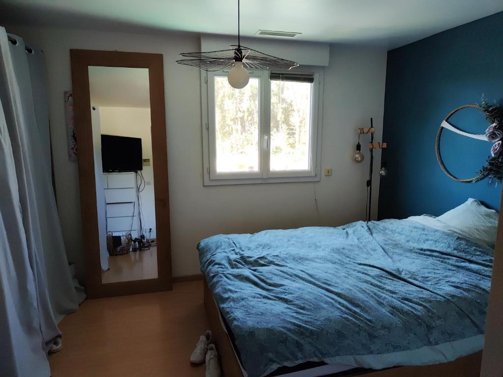 une chambre avec un lit, une fenêtre et un miroir dans l'établissement Villa avec piscine spacieuse, à Saint-Jean-de-Védas
