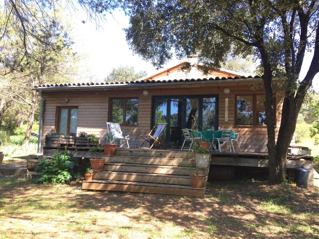 Cette cabane en rondins dispose d'une terrasse couverte. dans l'établissement Maison en pleine nature, à Aniane