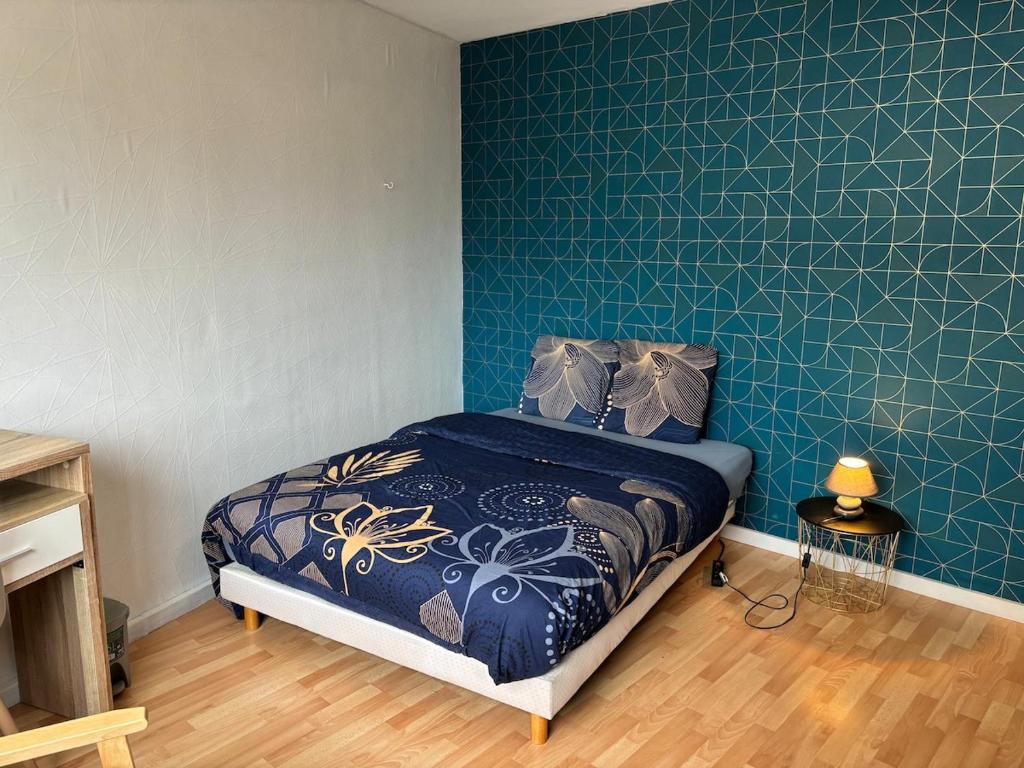 une chambre avec un lit avec un mur bleu dans l'établissement Coloc Cursat I Green Room, à Annemasse