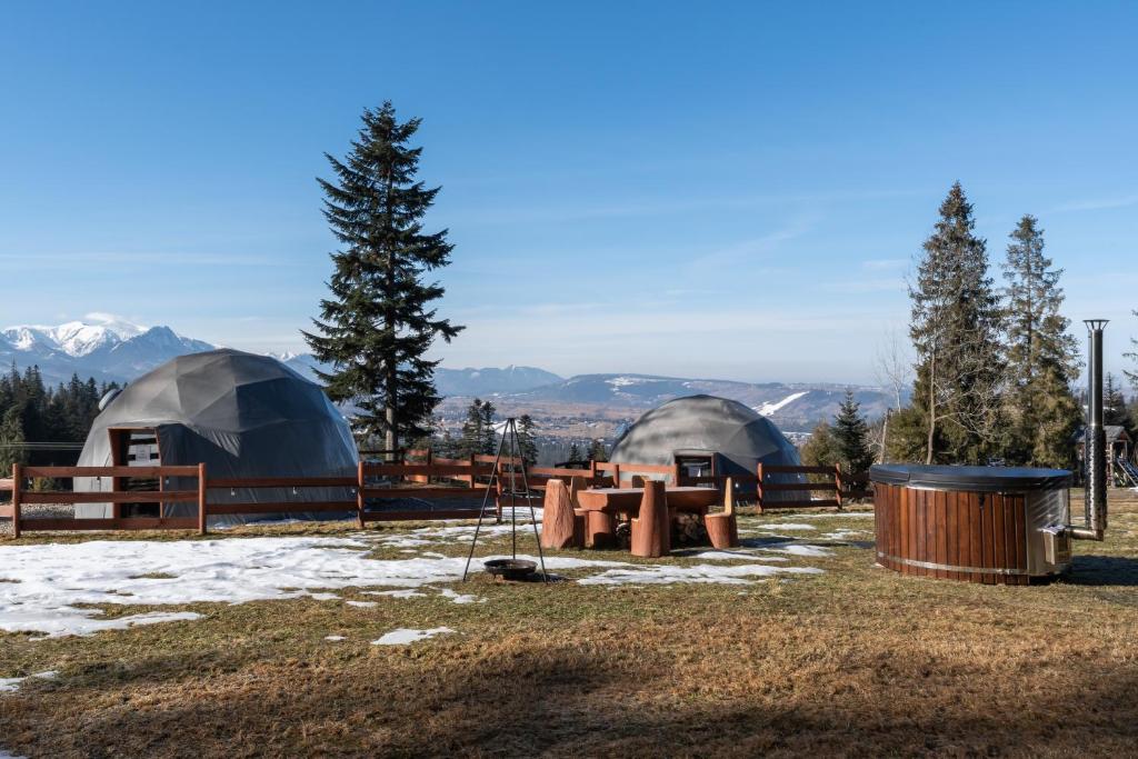 a group of tents in a field with snow at Tatra Glamp Tarasówka - Sieć noclegowa Tatra Glamp in Poronin
