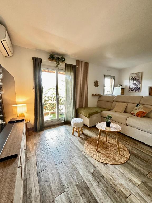 un salon avec un canapé et une table dans l'établissement Charmant studio - parking & clim - plage, à Vallauris