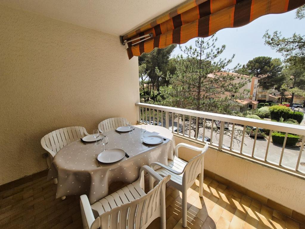 une table et des chaises sur un balcon avec une fenêtre dans l'établissement Joli studio à 350 m de la plage de Saint Asile, tout à pied., à Saint-Mandrier-sur-Mer