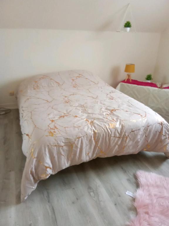 un lit avec une couette dessus dans une chambre dans l'établissement Maison Sologne, à Lassay-sur-Croisne