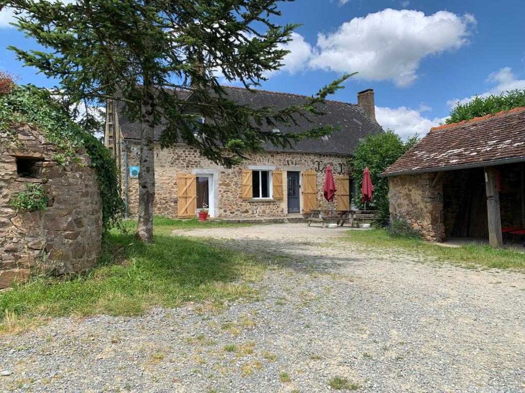 une ancienne maison en pierre avec une table et des chaises à l'extérieur dans l'établissement Gîte des Eperviers, à Étival