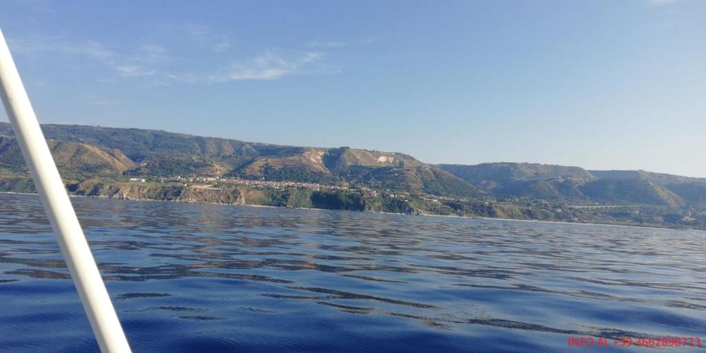 łódź na wodzie z górami w tle w obiekcie B&B Controtempo w mieście Reggio di Calabria