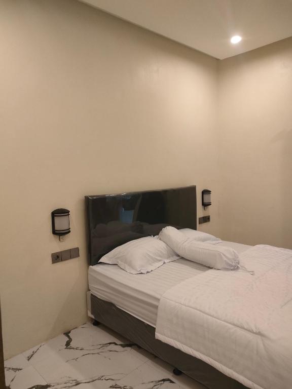 a bedroom with a bed with white sheets at GriyaAdelisca in Darmasaba