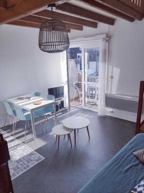 un salon avec une table et des chaises et un lit dans l'établissement Charmant Duplex tout confort, à La Rochelle