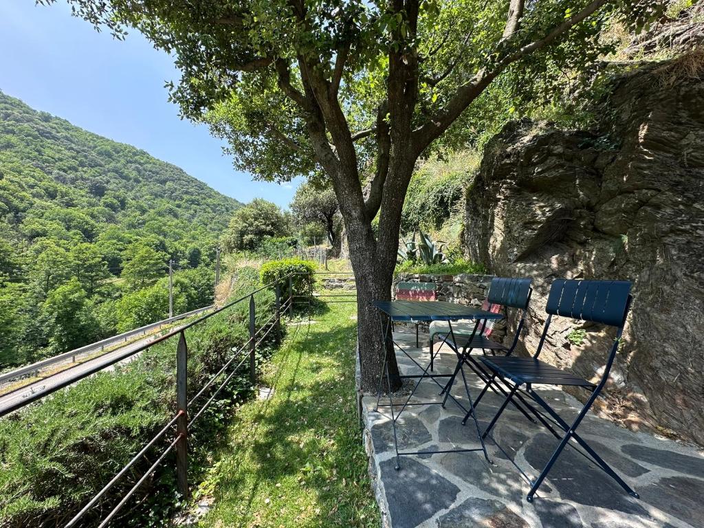 a table and chairs sitting under a tree on a balcony at La Clède du PontNeuf in Valleraugue