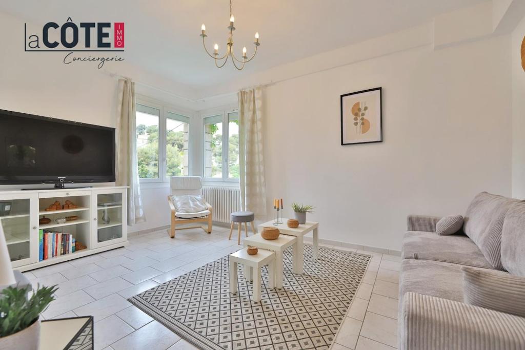 un salon avec un canapé et une télévision dans l'établissement Le Rocher, à Carry-le-Rouet