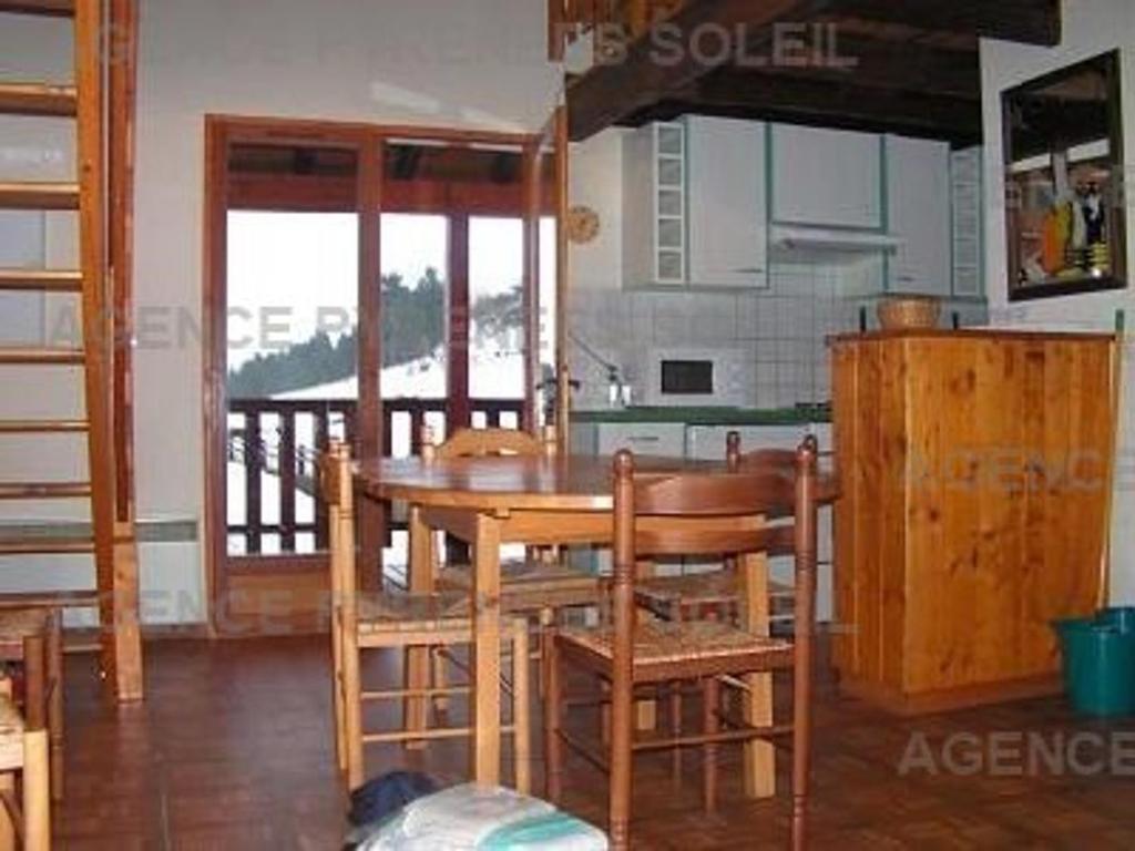 - une cuisine avec une table et des chaises en bois dans la chambre dans l'établissement Chalet 3 chambres avec terrasse aux Angles - FR-1-295-145, aux Angles
