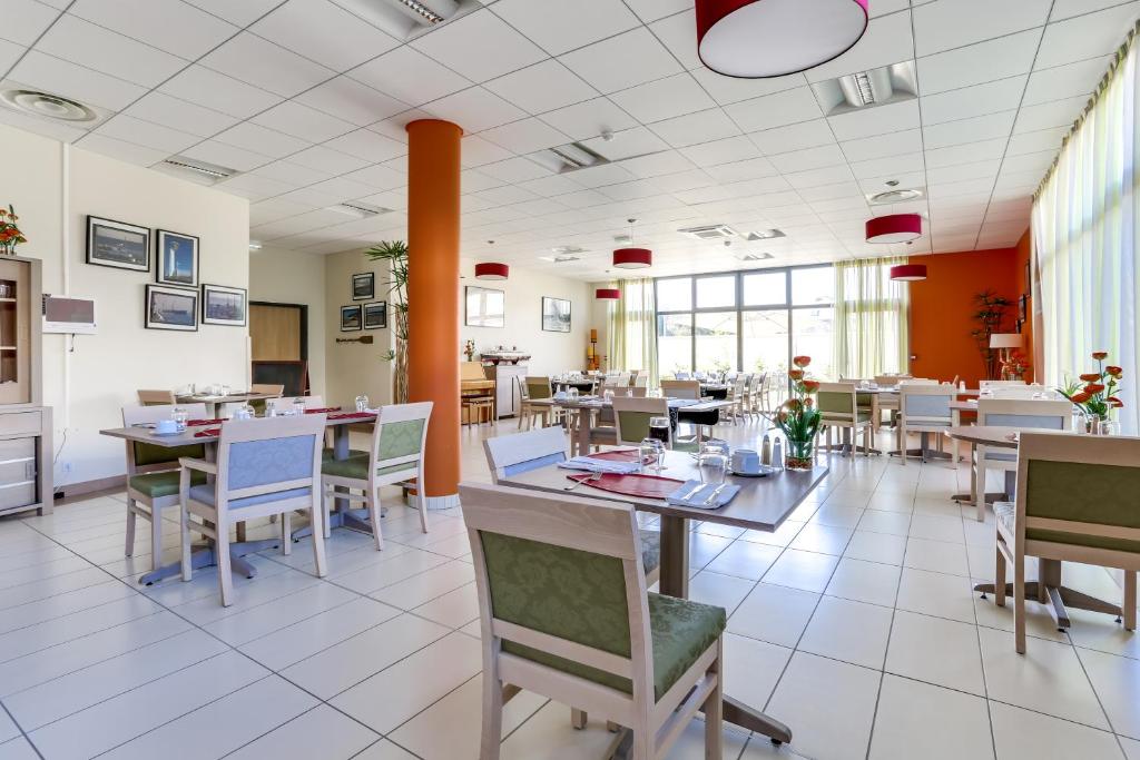 a dining room with tables and chairs in a restaurant at Zenitude Hôtel-Résidences Le Havre Les Docks in Le Havre