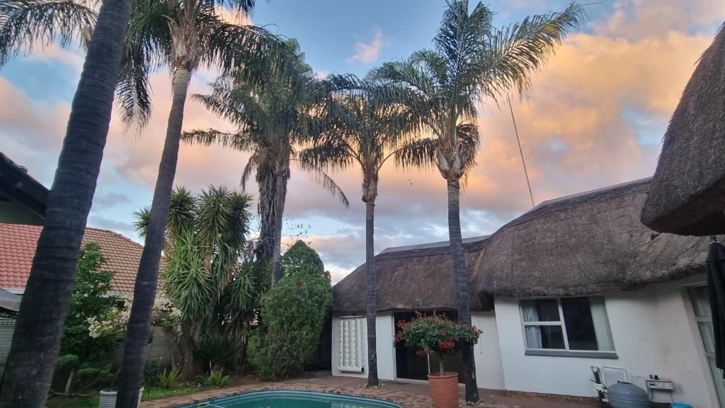 una casa con palme e una piscina di Carrington Cottage a Kimberley