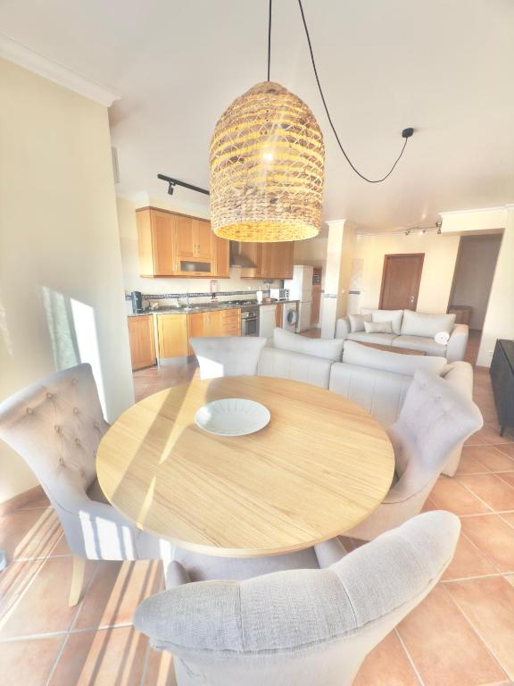 a dining room with a wooden table and white chairs at Casa De Sousa-Refúgio de Surf entre Peniche e Ericeira in A dos Cunhados