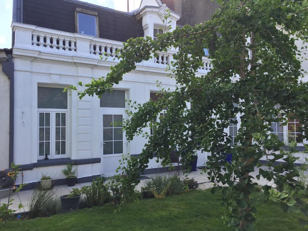 une maison blanche avec un toit noir dans l'établissement Grand studio tout confort dans l'hyper centre, à Valenciennes