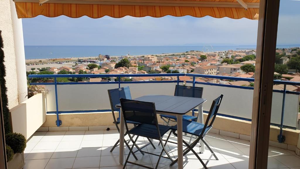 une table et des chaises sur un balcon avec vue dans l'établissement Saint Pierre la mer - Nid d'aigle avec piscine à proximité de la grande plage, à Saint Pierre La Mer