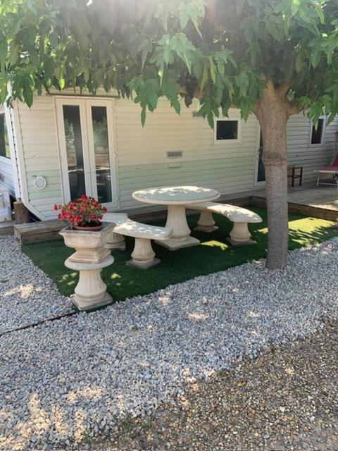 une table de pique-nique et un arbre devant une maison dans l'établissement Mobil Home dans propriété privée, à Béziers