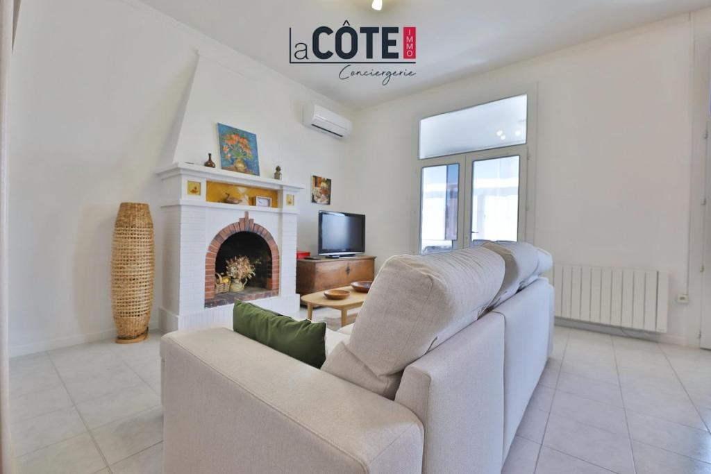 un salon avec un canapé et une cheminée dans l'établissement L'Oursinade, à Carry-le-Rouet