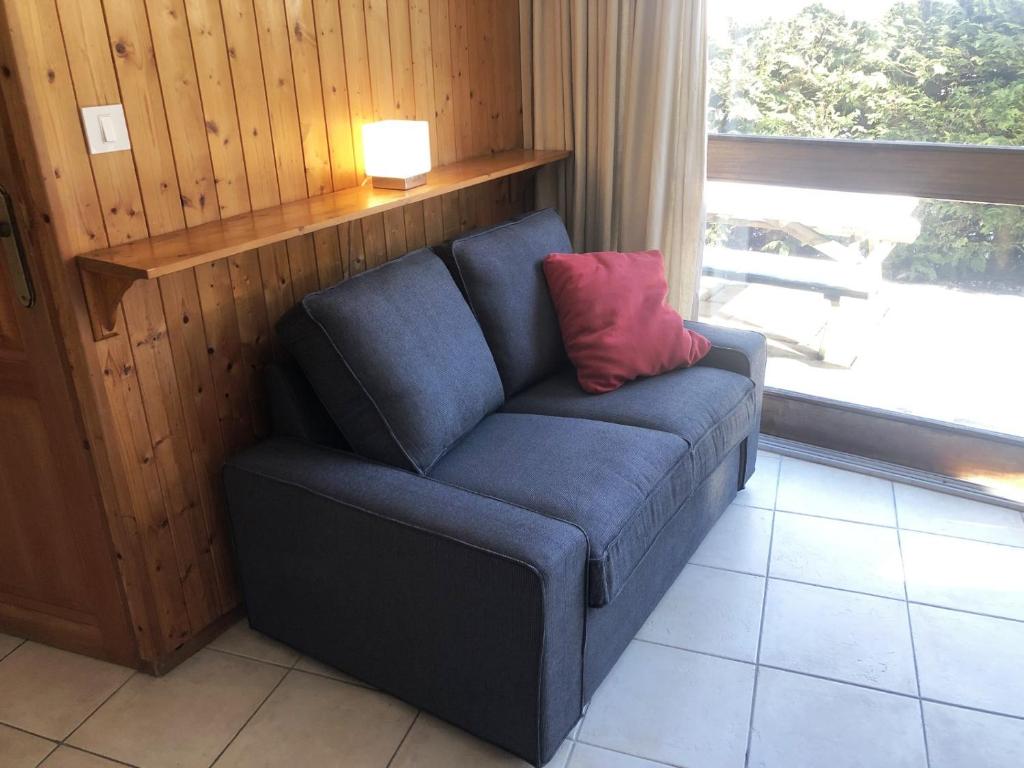 a blue couch with a red pillow in a living room at Chalet Leslie in Morzine