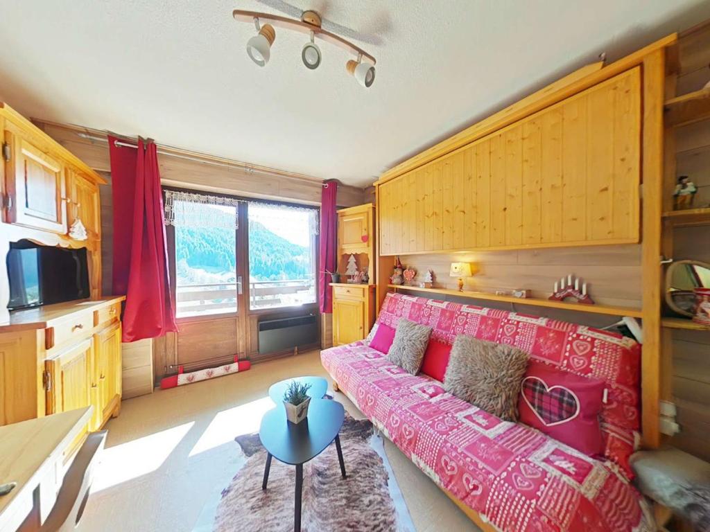 un salon avec un canapé rouge et une table dans l'établissement Studio 4 Pers. avec Balcon Sud, Parking et Navette - Le Grand-Bornand - FR-1-241-221, au Grand-Bornand