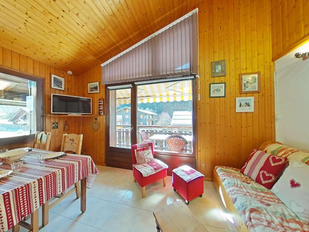 - un salon avec deux tables et une télévision dans l'établissement Studio/Cabine/Mezz 5 pers avec navette, à 600m du centre - Le Grand-Bornand - FR-1-241-165, au Grand-Bornand