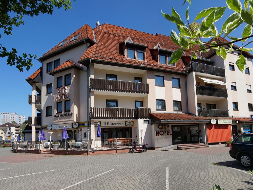 um grande edifício com um telhado vermelho numa rua em City Hotel Mark Michelstadt em Michelstadt