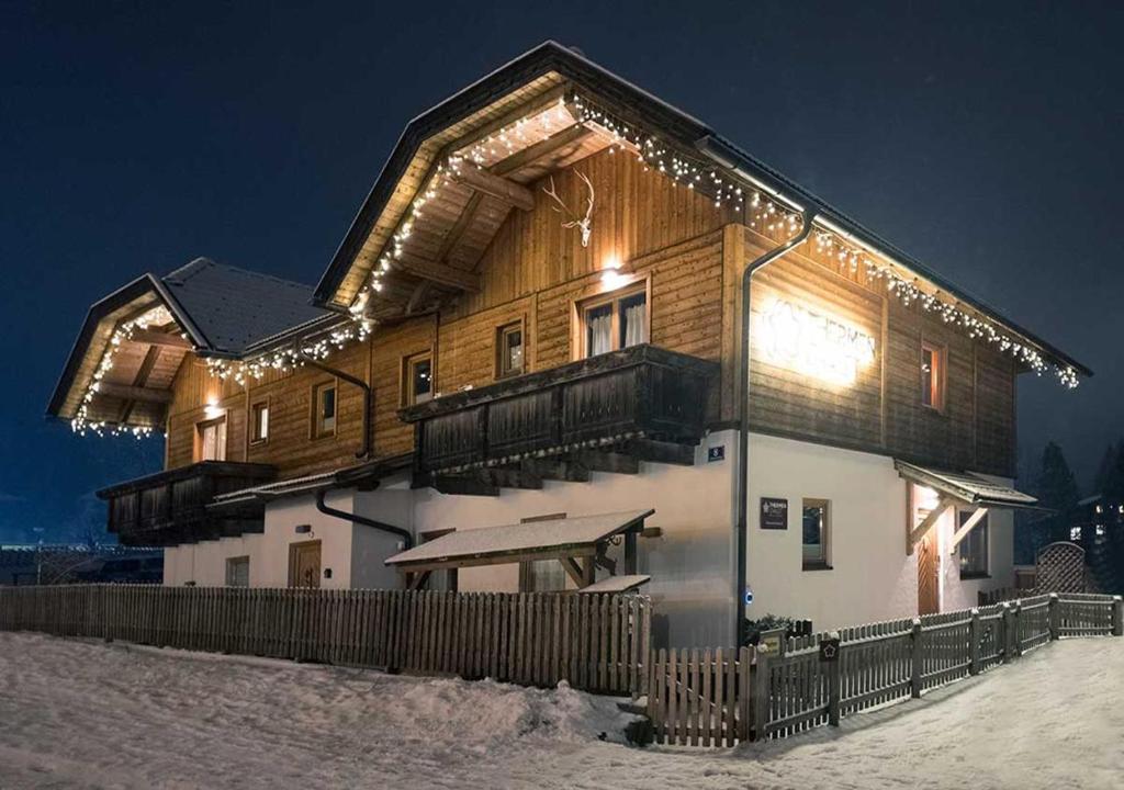 a house with lights on it in the snow at Thermenchalet in Bad Kleinkirchheim