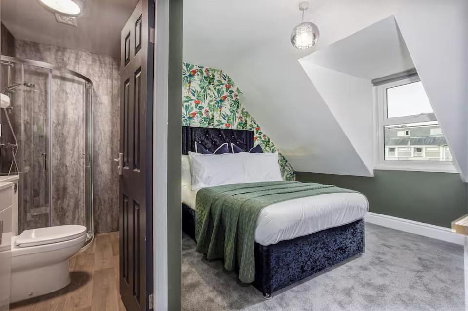 a bedroom with a bed and a bathroom with a toilet at Room 8 ,double room with private bathroom with optional additional single room room 7 for third guest, 23 Deganwy Avenue in Llandudno