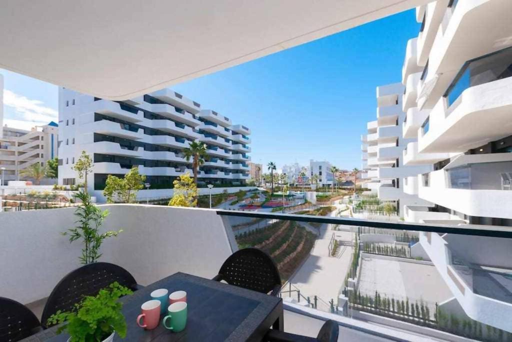 un balcon avec une table et des chaises et un bâtiment dans l'établissement Apartamento costero en una comunidad de lujo, à Arenales del Sol