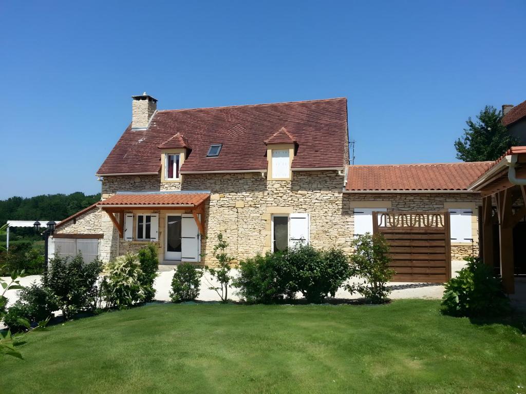 une maison avec une pelouse verte devant elle dans l'établissement Terre De Pierres - Gite Aventurine, à Saint-Geniès